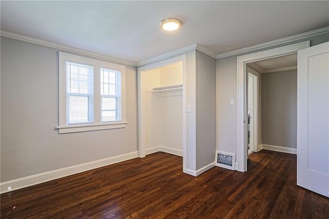 unfurnished bedroom featuring crown molding, dark wood-type flooring, and a closet