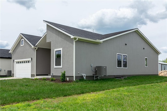 149 S Linn Valley Dr, Linn Valley, KS 66040 - view of side of property featuring a garage, a yard, driveway, central air condition unit, and a shingled roof
