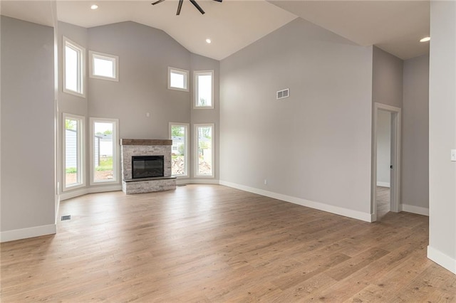 149 S Linn Valley Dr, Linn Valley, KS 66040 - unfurnished living room with a ceiling fan, high vaulted ceiling, light wood finished floors, baseboards, and a stone fireplace