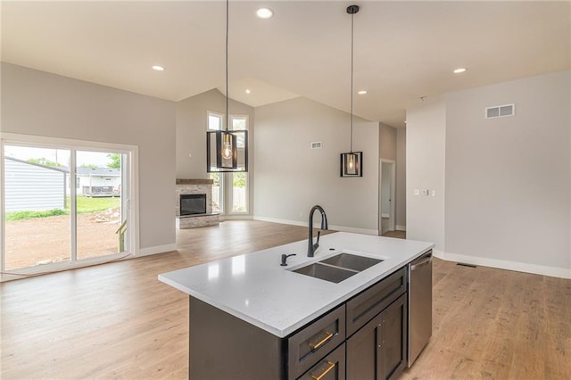 149 S Linn Valley Dr, Linn Valley, KS 66040 - kitchen featuring a sink, light wood-type flooring, lofted ceiling, dishwasher, and a stone fireplace