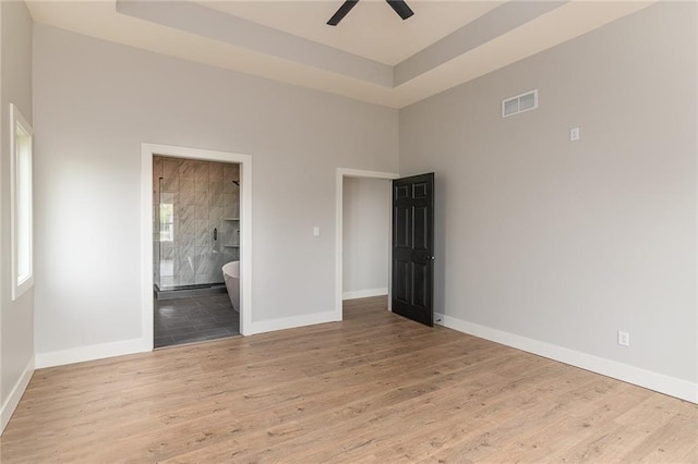 149 S Linn Valley Dr, Linn Valley, KS 66040 - unfurnished room featuring ceiling fan, wood finished floors, baseboards, and a tray ceiling