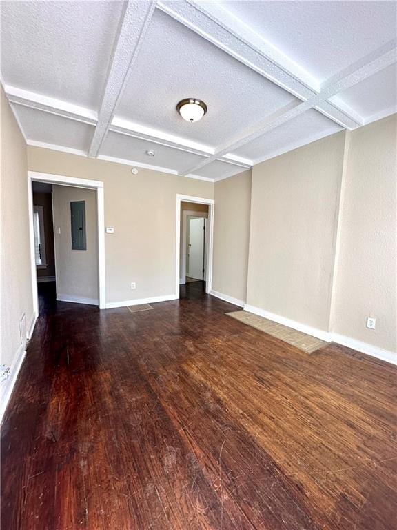 spare room featuring dark hardwood / wood-style flooring, coffered ceiling, beamed ceiling, and a textured ceiling