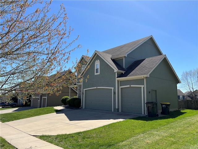 view of front facade with a garage, fence, driveway, roof with shingles, and a front yard