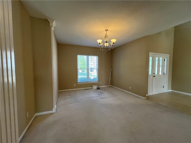 carpeted empty room featuring a notable chandelier