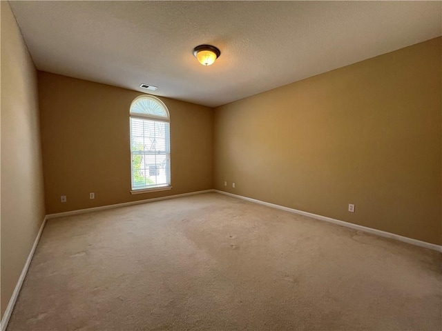 unfurnished room featuring a textured ceiling and carpet