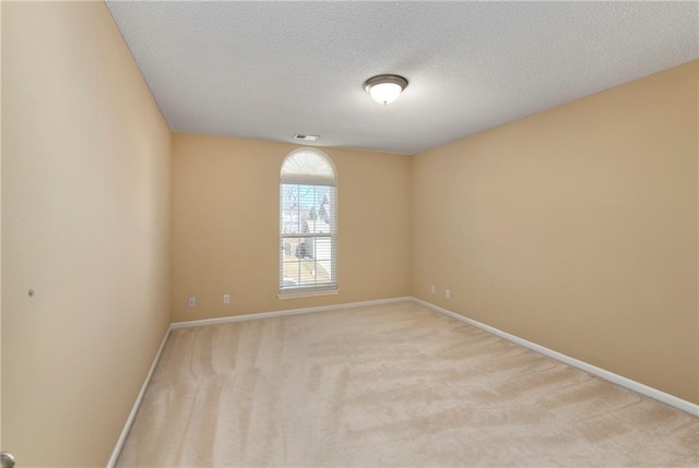 unfurnished room featuring carpet floors, visible vents, a textured ceiling, and baseboards