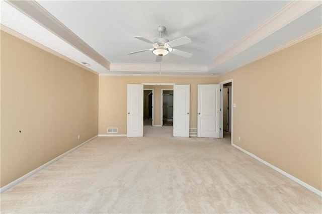 unfurnished room featuring ornamental molding, a raised ceiling, and baseboards