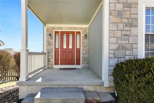 doorway to property with stone siding and stucco siding