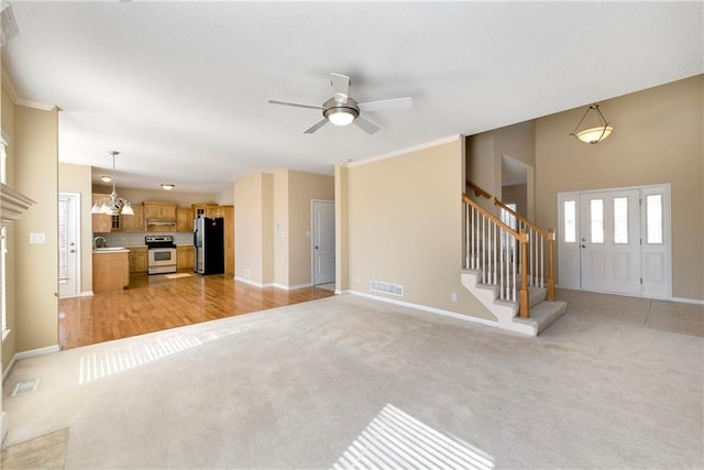 unfurnished living room with light carpet, stairway, baseboards, and visible vents