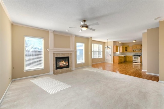 unfurnished living room featuring light colored carpet, a fireplace, a textured ceiling, and baseboards