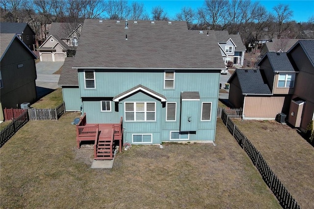 rear view of house with a residential view, a fenced backyard, a lawn, and a wooden deck