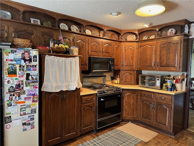 kitchen featuring dark parquet flooring, black appliances, and a textured ceiling