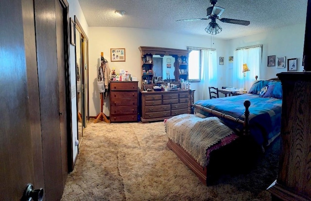 carpeted bedroom with ceiling fan and a textured ceiling