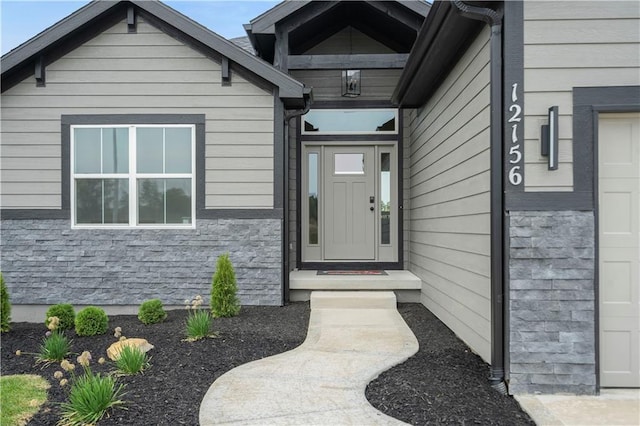 entrance to property with stone siding and a garage