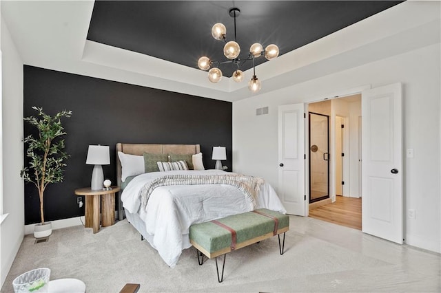 bedroom with an inviting chandelier and a tray ceiling