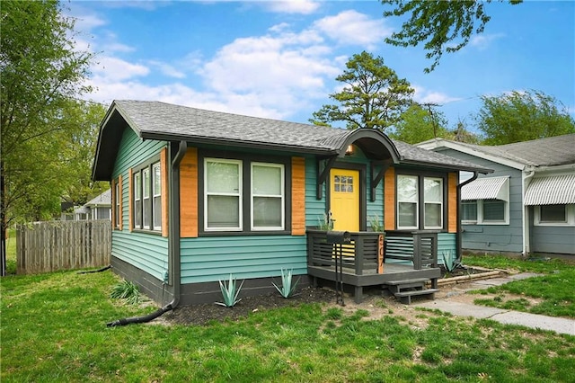 view of front of home with a wooden deck and a front lawn