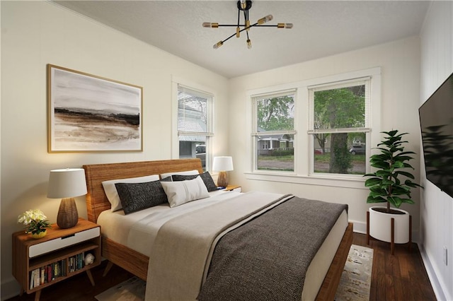 bedroom with dark hardwood / wood-style flooring and a chandelier