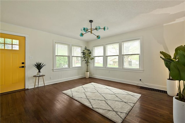 foyer entrance featuring a chandelier and dark hardwood / wood-style floors