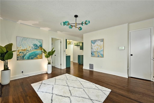 interior space with a textured ceiling, dark wood-type flooring, and a chandelier