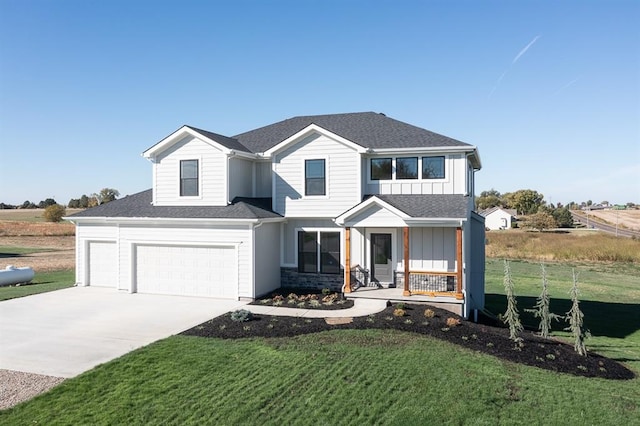 view of front of home featuring a porch, a garage, and a front yard