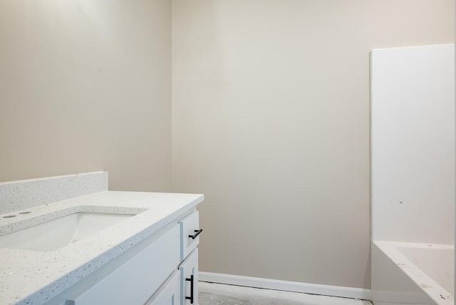 bathroom featuring a washtub and vanity