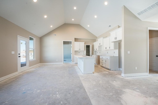 kitchen featuring a kitchen island, high vaulted ceiling, backsplash, and white cabinetry