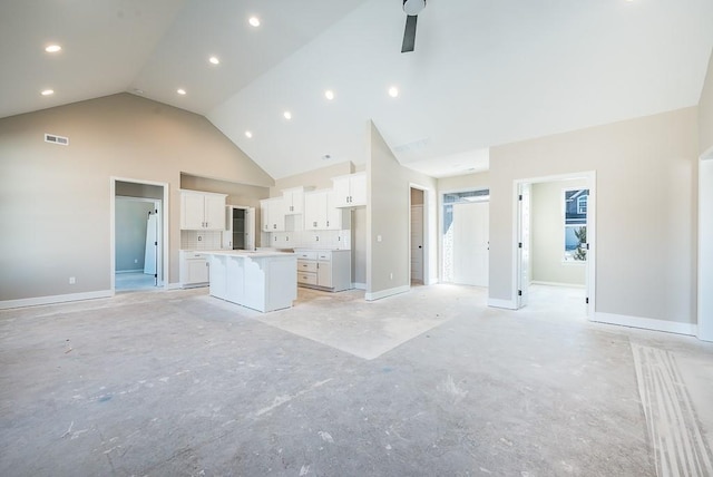 unfurnished living room featuring ceiling fan and high vaulted ceiling