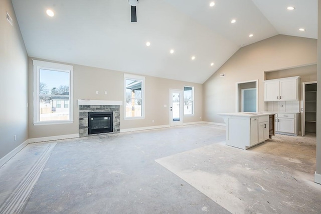 unfurnished living room featuring lofted ceiling, a fireplace, and ceiling fan