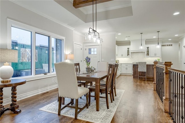 dining room with ornamental molding and dark hardwood / wood-style flooring