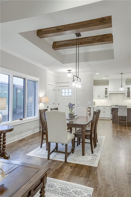 dining area with dark hardwood / wood-style flooring, beamed ceiling, ornamental molding, and plenty of natural light