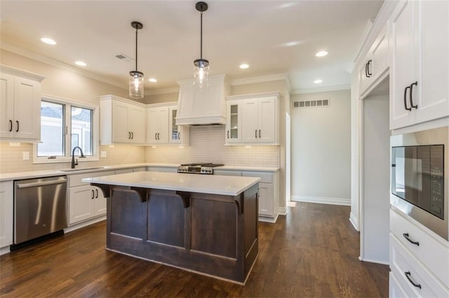 kitchen featuring hanging light fixtures, white cabinetry, dark wood-type flooring, sink, and stainless steel appliances