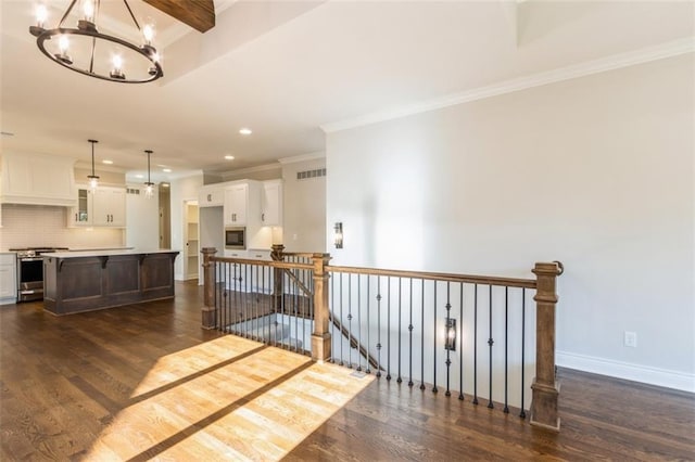 interior space with ornamental molding, an inviting chandelier, and dark hardwood / wood-style floors