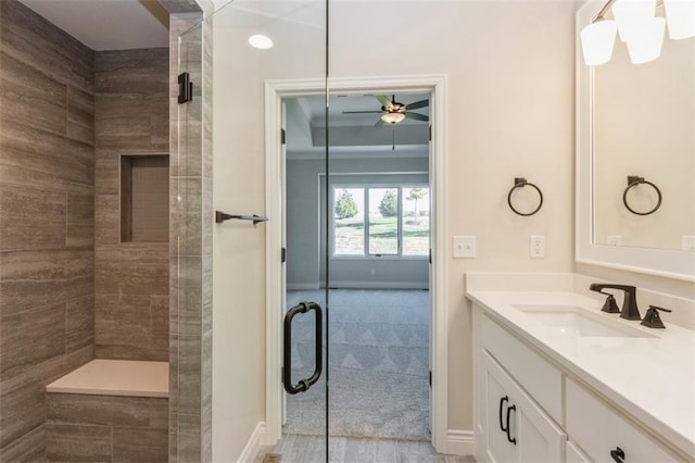 bathroom featuring a shower with door, vanity, and ceiling fan