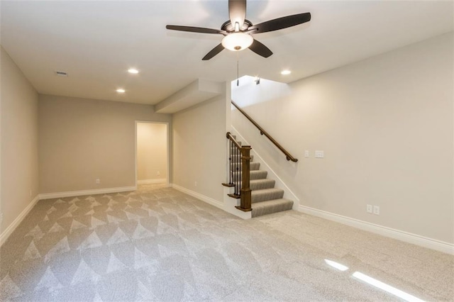 basement featuring ceiling fan and light colored carpet