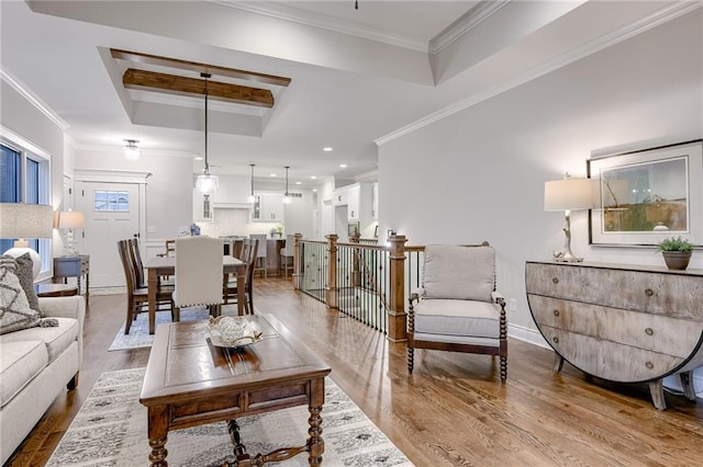 living room featuring hardwood / wood-style flooring, ornamental molding, and a raised ceiling