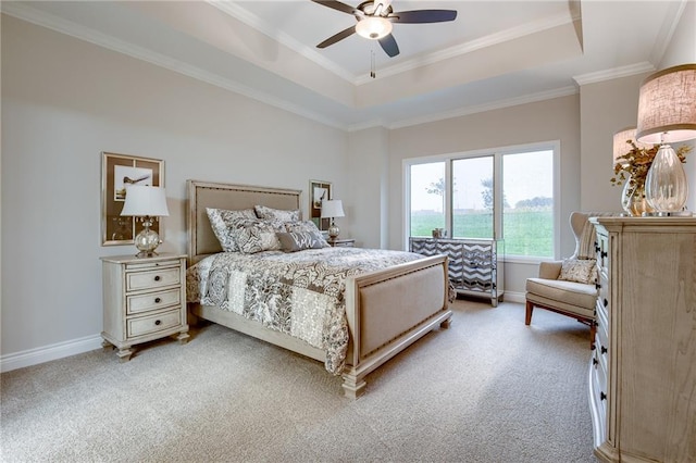 carpeted bedroom featuring crown molding, a tray ceiling, and ceiling fan