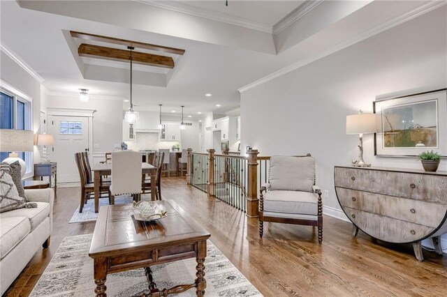 living room featuring hardwood / wood-style floors, crown molding, and a tray ceiling