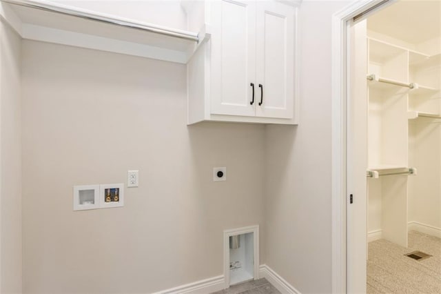 clothes washing area featuring cabinets, hookup for an electric dryer, and hookup for a washing machine