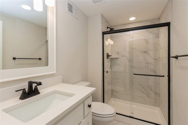 bathroom with vanity, a shower with shower door, and toilet