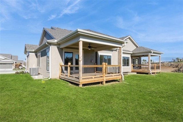 rear view of property featuring a deck, a lawn, and ceiling fan