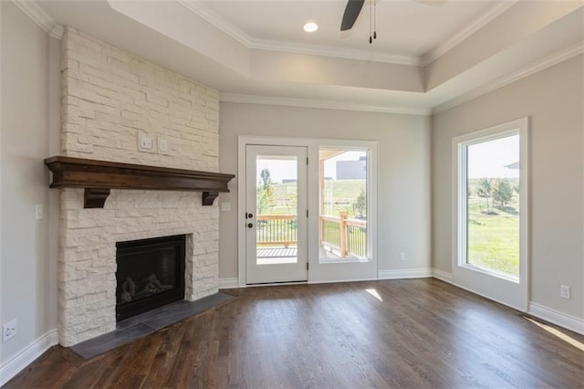 unfurnished living room featuring ceiling fan, a stone fireplace, ornamental molding, and dark hardwood / wood-style floors