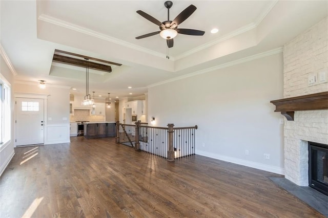 unfurnished living room featuring crown molding, dark hardwood / wood-style floors, and a tray ceiling