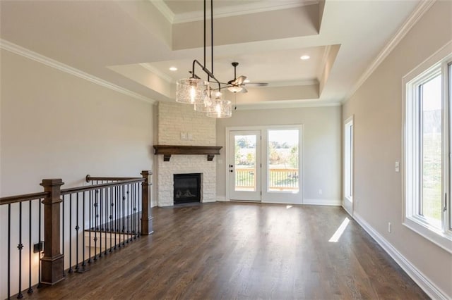 unfurnished living room featuring crown molding, dark hardwood / wood-style floors, and a tray ceiling