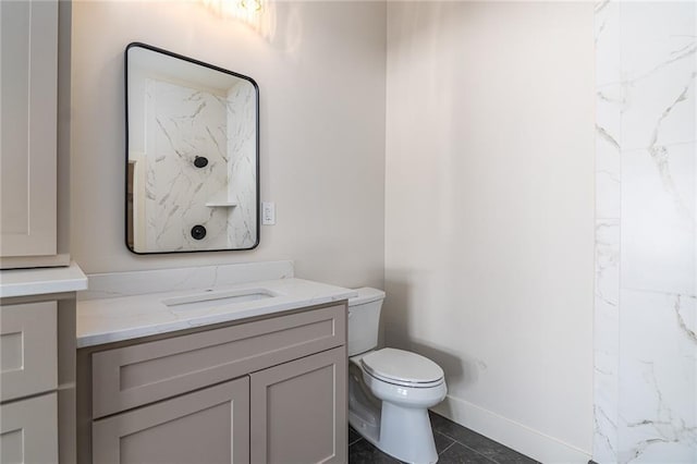 bathroom featuring toilet, baseboards, vanity, and tile patterned floors