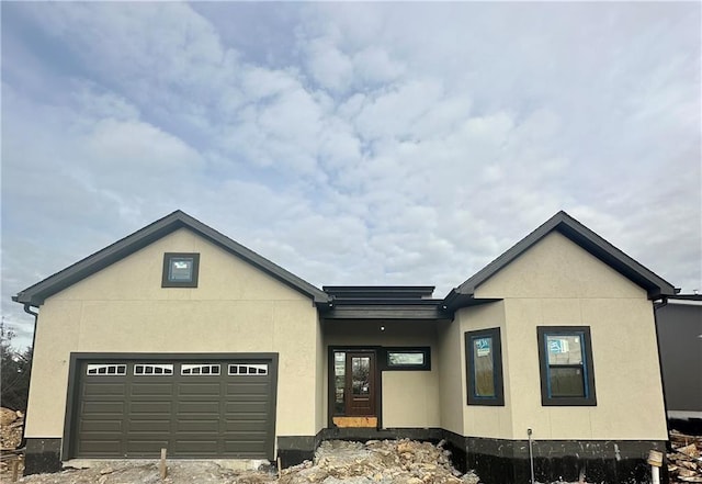 view of front of home with a garage and stucco siding