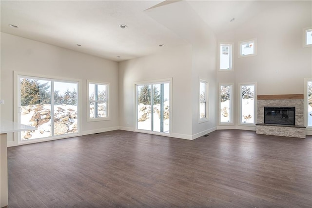 153 S Linn Valley Dr, Linn Valley, KS 66040 - unfurnished living room with dark wood-style flooring, a high ceiling, a fireplace, baseboards, and recessed lighting