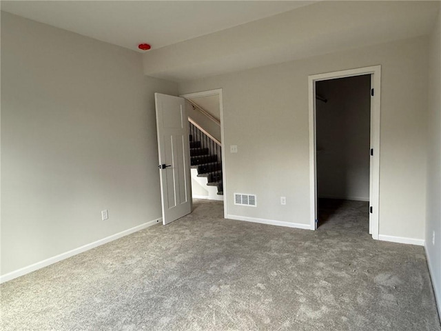 unfurnished bedroom with carpet and a spacious closet