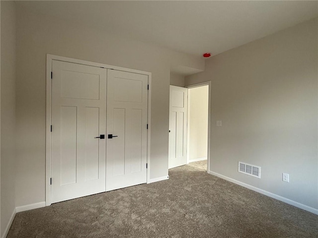 unfurnished bedroom featuring carpet flooring and a closet