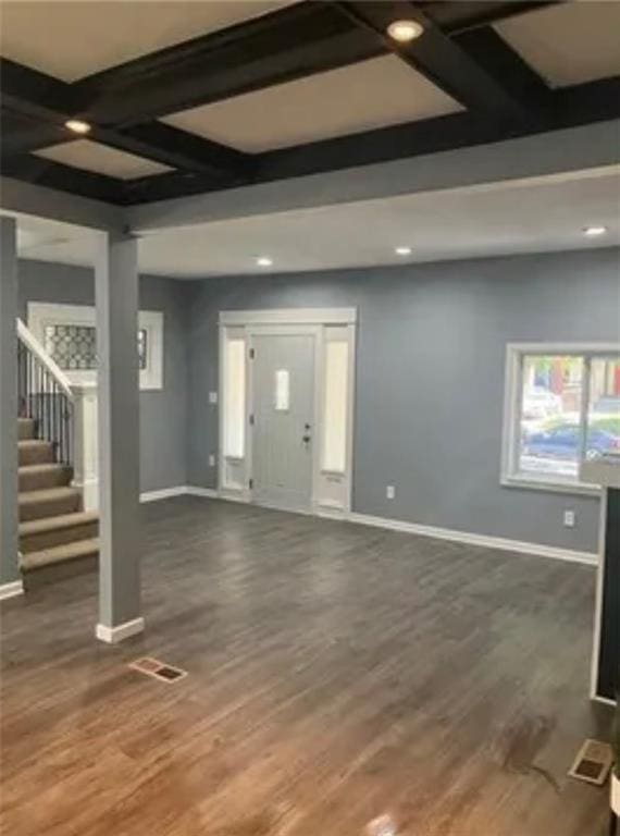 spare room with coffered ceiling, beamed ceiling, and dark hardwood / wood-style floors