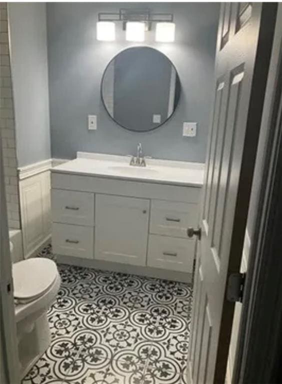 full bathroom featuring vanity with extensive cabinet space, tub / shower combination, toilet, and tile flooring